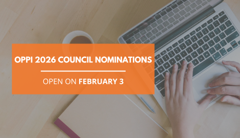 A person typing on a laptop with a journal, pen and mug aesthetically beside them.