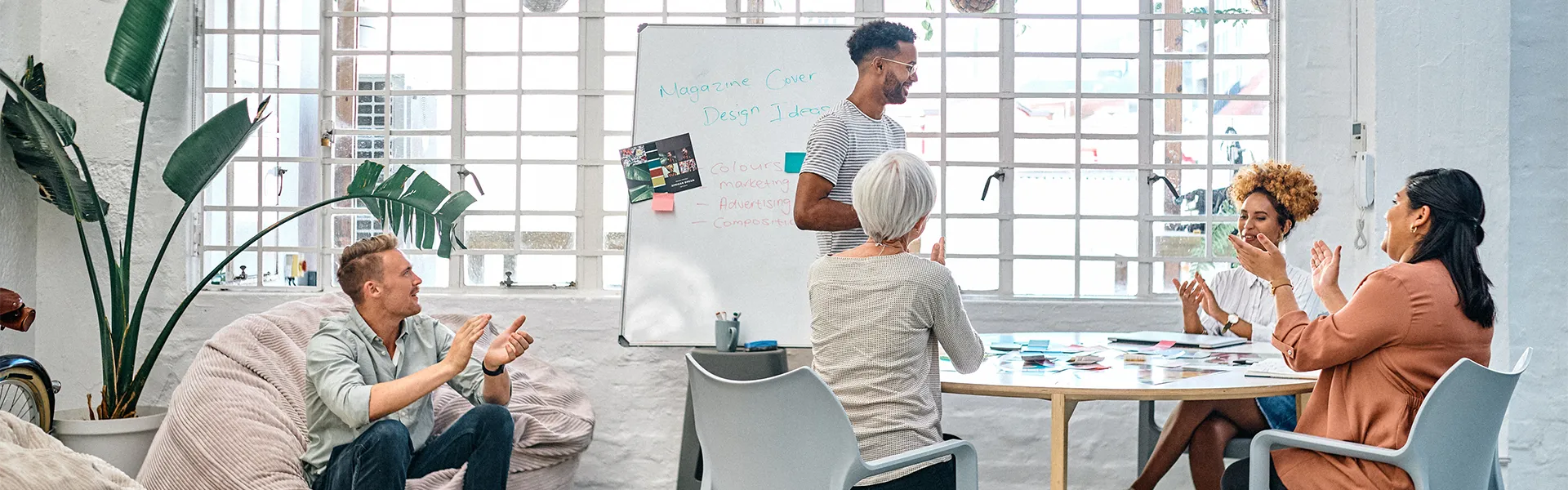 A discussion with several individuals in a conference room. Individuals are clapping.