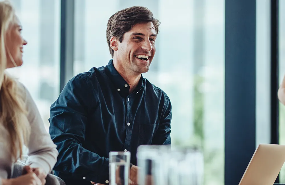 A man laughing and smiling in an office environment