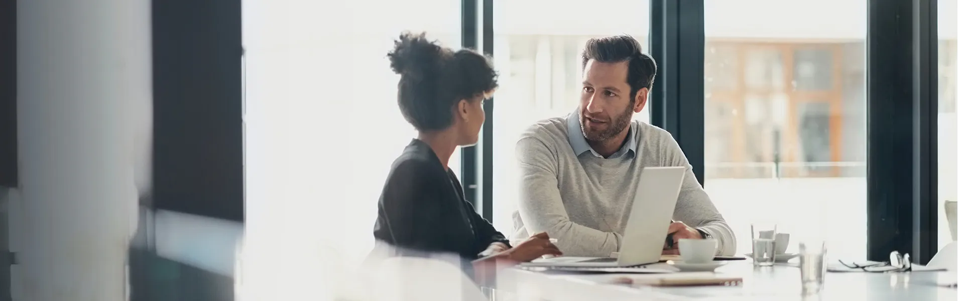 Two individuals talking in an office conference room