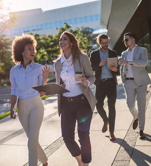 Two groups of people walking in a business courtyard in discussion