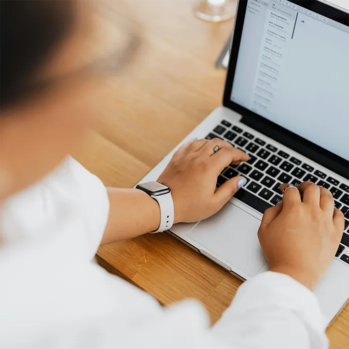 Looking over a persons shoulder at them working on a laptop computer