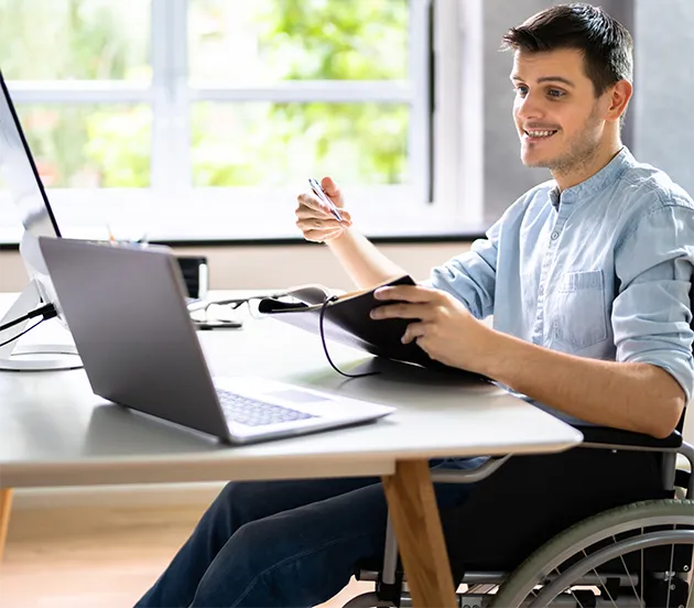 Student in a wheelchair sitting at an office desk