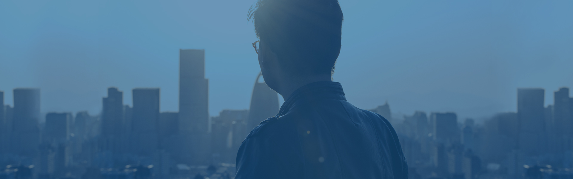 Gentleman staring off into the distance with a city in the background