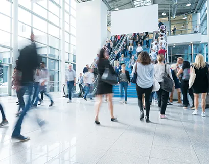 Individuals walking in a bright open hallway