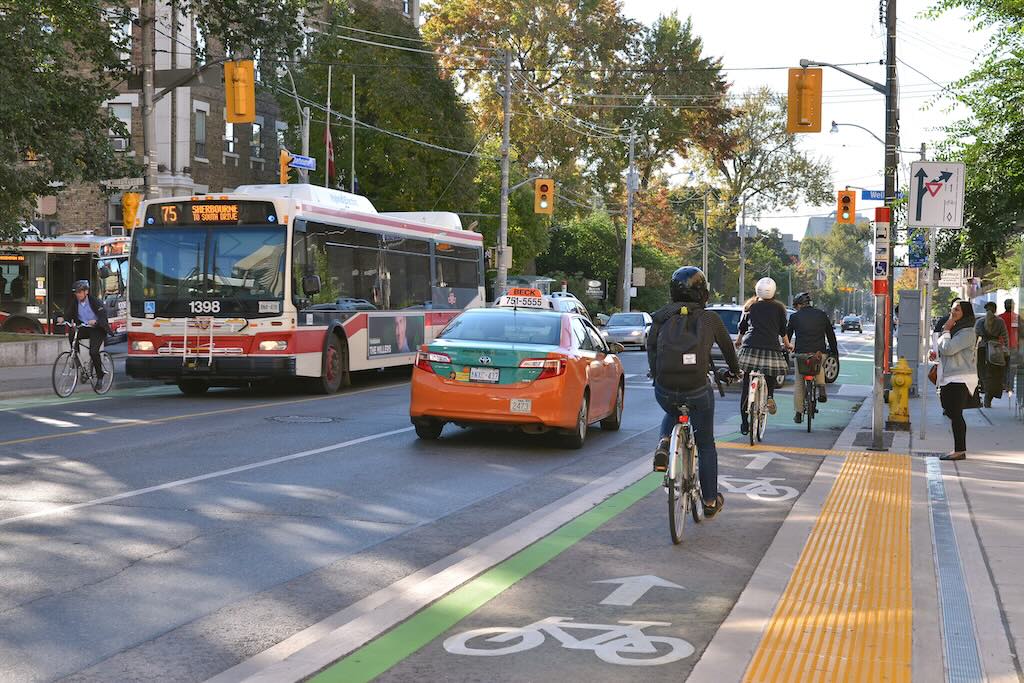 A busy city street with a busy set of individuals in a bike lane
