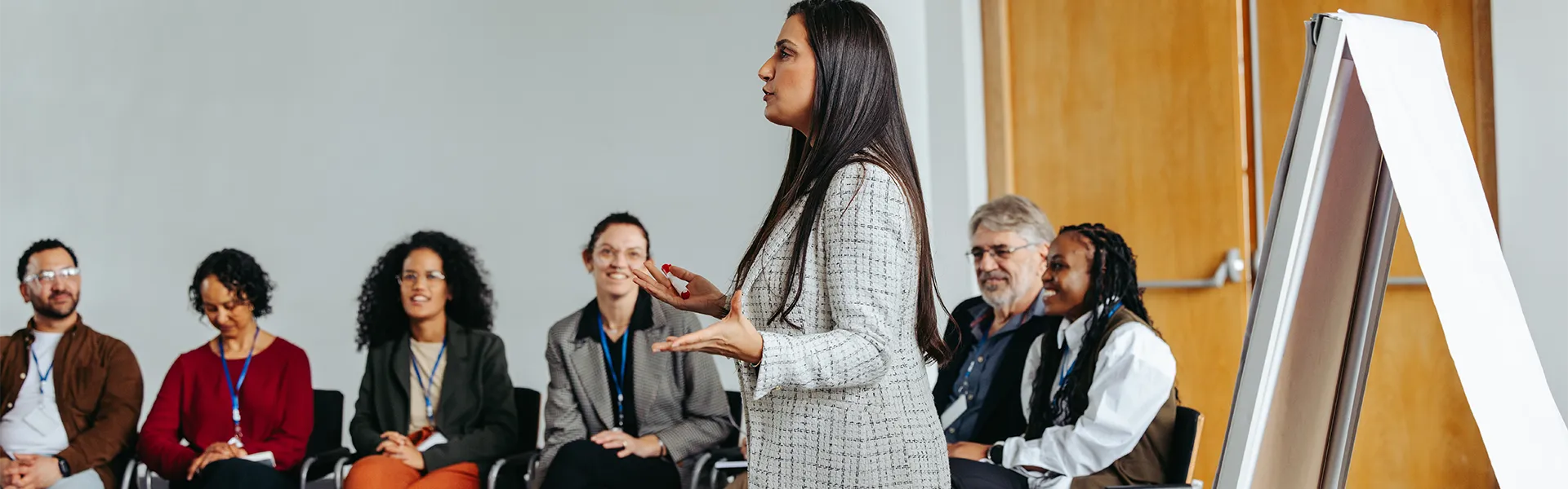 Lady giving a speech infront of a group of individuals