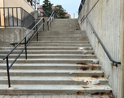 Staircases near Calumet College with broken steps and wide space between railings